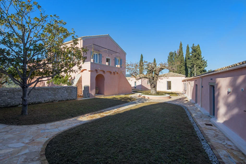 Pink villa showing steps to terrace with olive trees in court-yard garden
