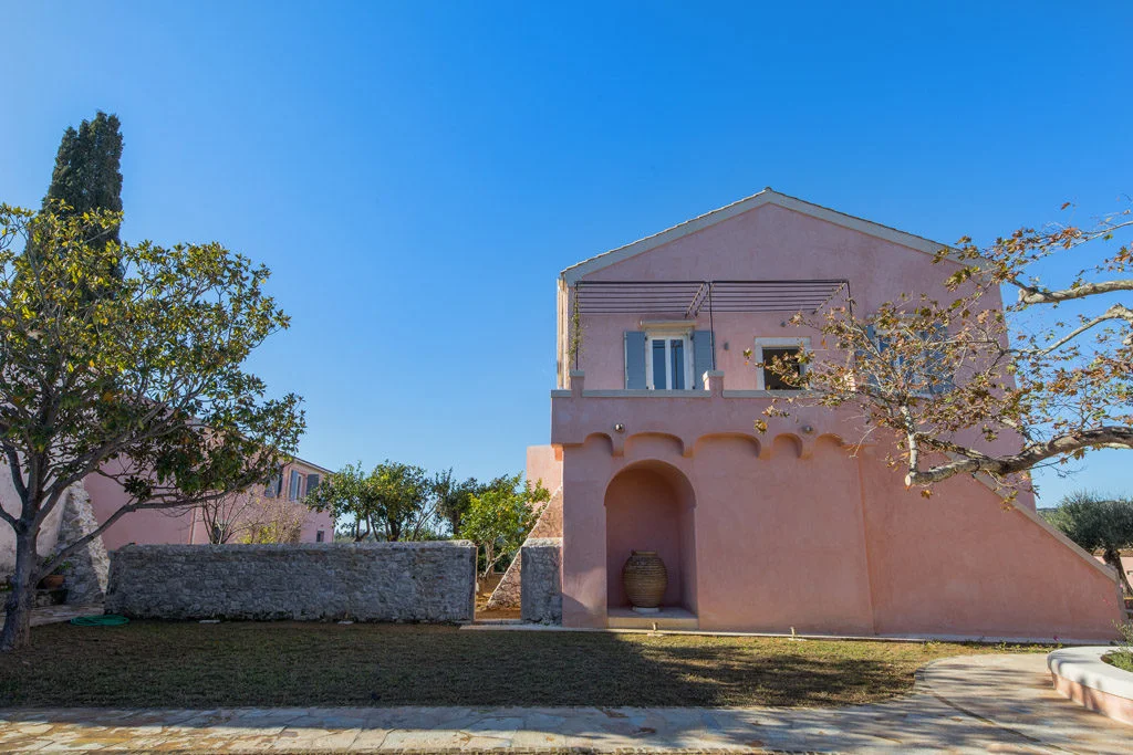 Pink villa showing steps to terrace with olive trees in court-yard garden