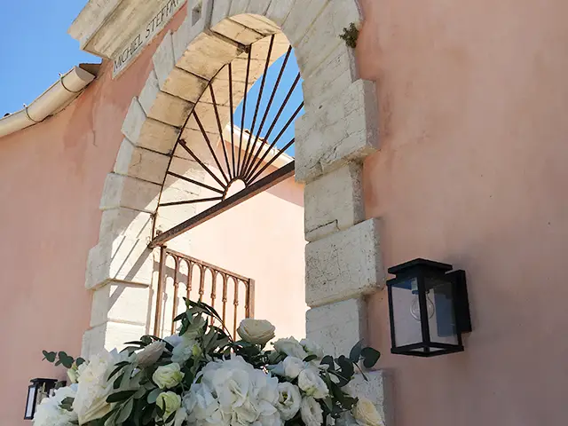 Iron gate entrance of The Courti Estate, Corfu with pink walls
