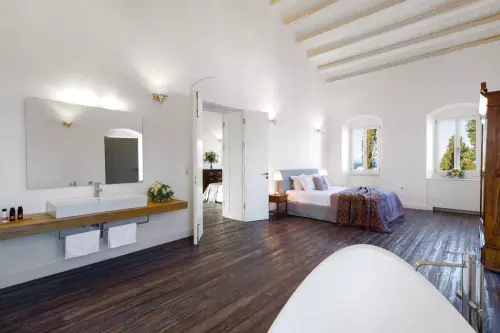 Bedroom with two windows showing sea and mountain views