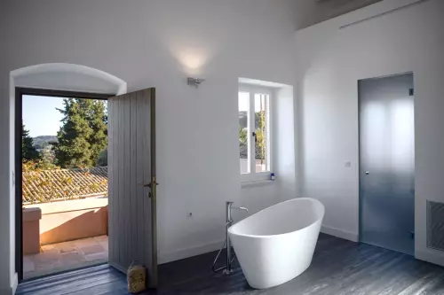 White free standing bath with chrome tap. Door leading outside to terrace.