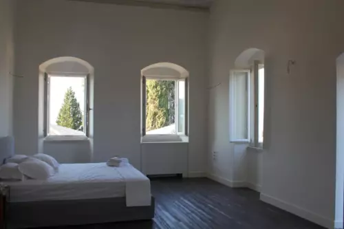 Bedroom with white walls three windows with views outside
